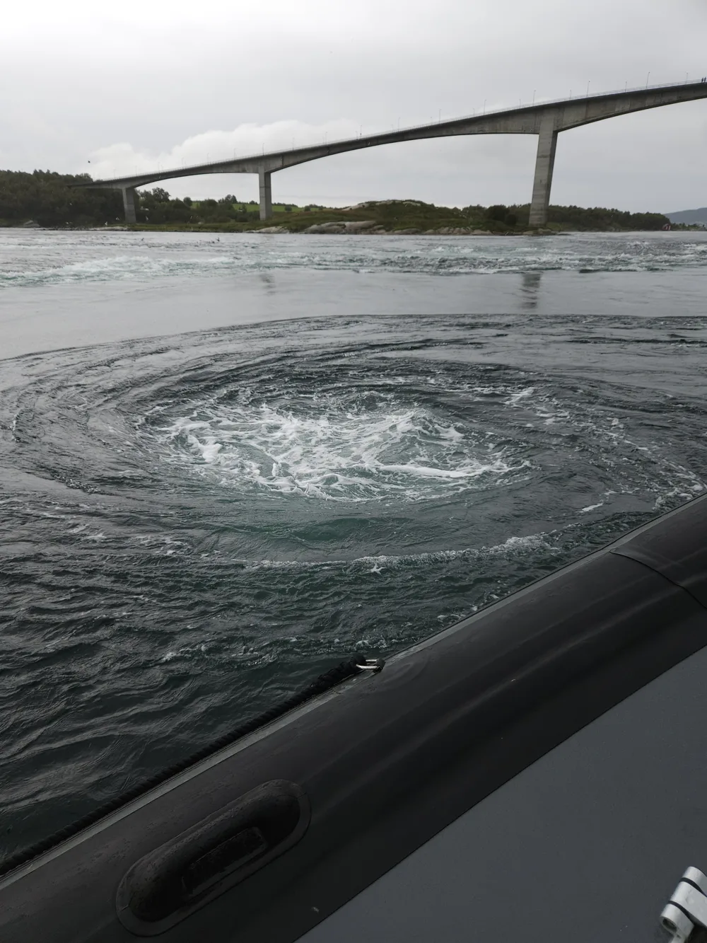 Originalbilde fra båt i Saltstraumen: malstrøm i sjøen, bro og båtripe synlig